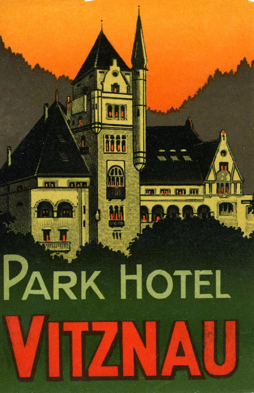 Picturesque view of grand hotel at sunset nestled between the forest and surrounding mountains; orange, green, black