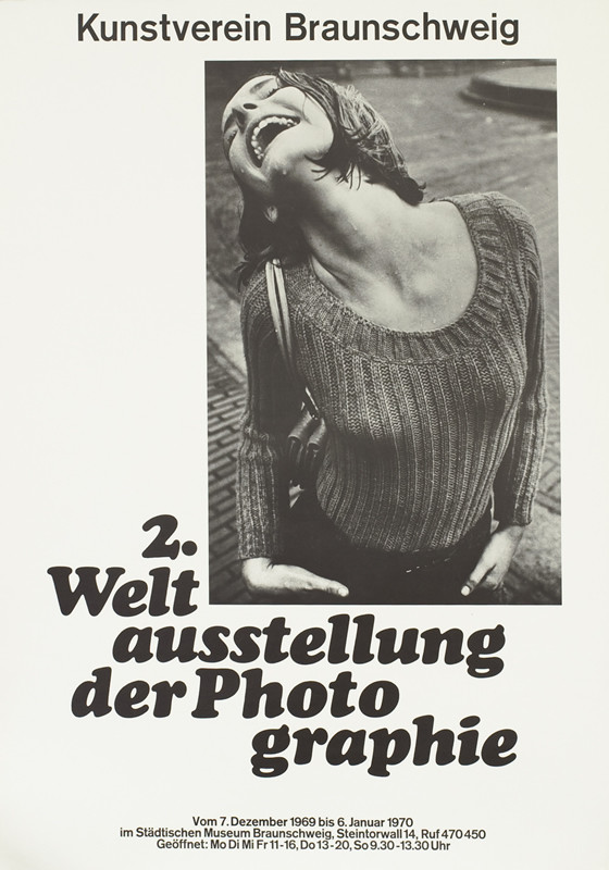 Photograph of woman smiling, head thrown back, in the rain; black, white