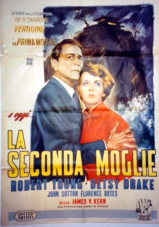 Couple embrace, with haunted house in background; red, blue, yellow