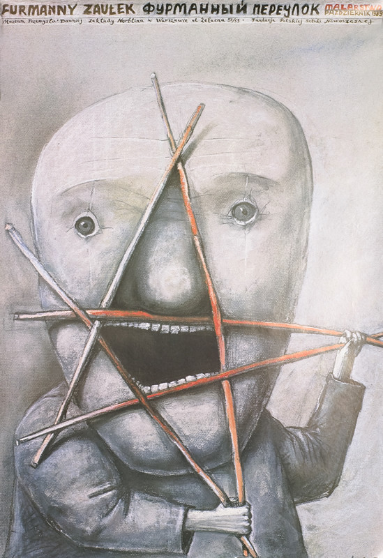 Man poses with sticks in star-shape pressed against face; red, gray, pink