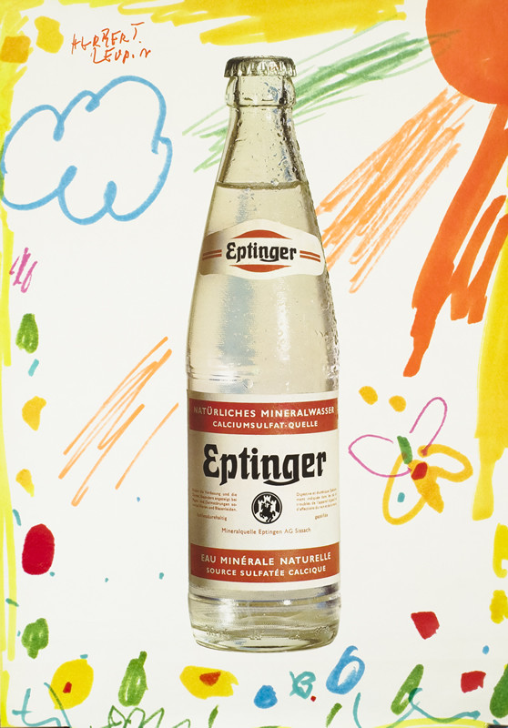 A bottle of Eptinger, childish drawing in background; yellow, orange