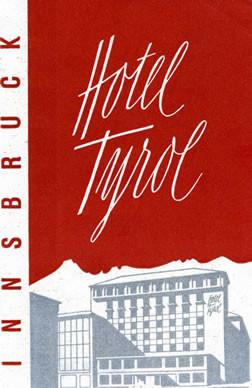 View of hotel, mountains behind; red, white, silver